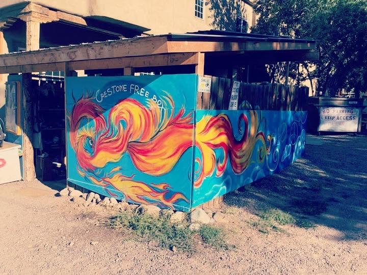 The Crestone Freebox building, covered in a vibrant turquoise mural of a fire bird